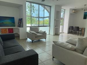 a living room with couches and a couch and chairs at Casa La Ceiba in Cancún
