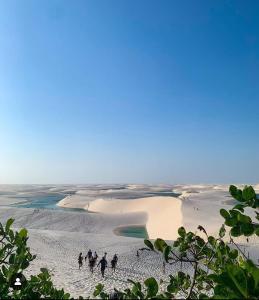 a group of people walking in the sand on a beach at Estadia in São Luís