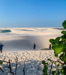 a group of people standing on top of a beach at Estadia in São Luís