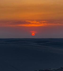 a sunset over the ocean with the sun in the sky at Estadia in São Luís