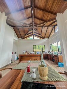 a living room with a wooden ceiling and a table at The Cloud Forest Retreat in Pelagallo