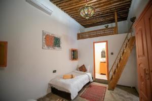 Un dormitorio con una cama en una habitación con escalera. en Riad merzg, en Fez