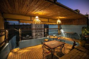 Un patio con mesas y sillas en un balcón. en Riad merzg, en Fez