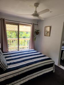 a bedroom with a large bed with a window at Bushland View Retreat in Ocean Shores