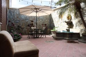 a patio with an umbrella and a table and chairs at Hostal Los Volcanes in Guatemala