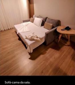 un letto in una camera con divano e tavolo di Laguetto Bianca a Gramado Altre 6 foto