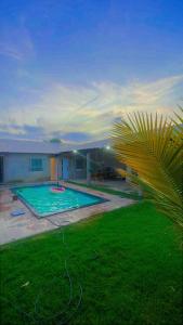 a backyard with a swimming pool and a palm tree at sitio para eventos in Caucaia