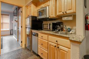 a kitchen with wooden cabinets and stainless steel appliances at Condo at Cedar Breaks Lodge in Brian Head, UT in Brian Head