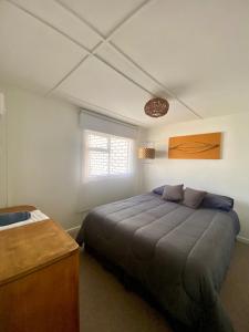 a bedroom with a large bed and a window at Casa Ovejero in Punta Arenas