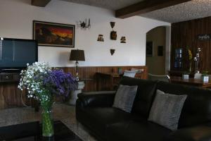 a living room with a black couch and a tv at Hostal Los Volcanes in Guatemala