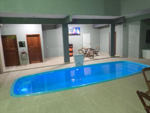 a large blue swimming pool in a room at Hotel Jardim Tropical in Boa Vista