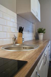 a kitchen counter with a sink in a kitchen at Apartamenty Młynowa in Białystok +23 photos