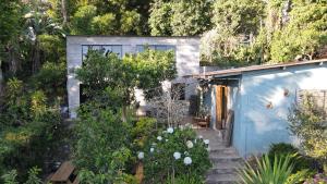 a blue house with a garden in front of it at Bambu Hostel in Juayúa
