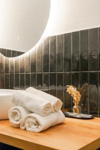 een stapel handdoeken zittend op een tafel in een badkamer bij Ventuno Dei Luxury Suites San Giovanni in Rome