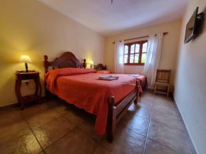 a bedroom with a red bed and a window at HOSTAL LA PLAZA IRUYA in Iruya