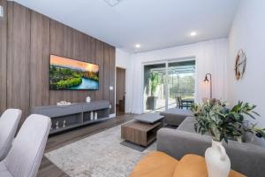 a living room with a couch and a tv on a wall at Doppio Westside in Orlando