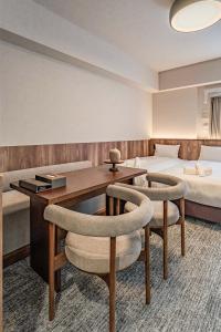 a hotel room with a bed and a desk and chairs at Apartment Hotel 11 Kuromon 4 in Osaka