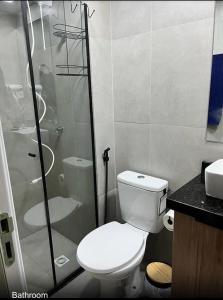 a bathroom with a toilet and a glass shower at Royal Luxury 305 in Poços de Caldas