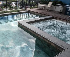 a swimming pool with a table and a chair in it at Novel Hotel Manila in Manila