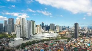 a city skyline with many tall buildings and traffic at Novel Hotel Manila in Manila