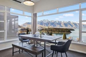 a dining room with a table and chairs and a large window at The BIGGEST & BEST VIEWS 3 Bedrooms WALK To Town in Queenstown