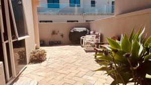a patio with chairs and plants on a balcony at Beachside Bliss in Tauranga