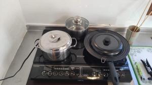 a stove top with two pots and pans on it at こにべ 平屋庭付き一棟貸し 棟脇駐車静かで便利なスーパー3分 in Miyazaki