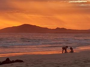 dos personas jugando en la playa al atardecer en Casa de Canelita, en Puerto Villamil