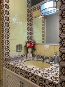 Un mostrador de baño con un lavabo y un espejo. en Casa Bugambilia Guanajuato, en Guanajuato