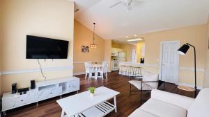 a living room with white furniture and a flat screen tv at Adorable 1BR condo with pool view at Magnolia in Myrtle Beach