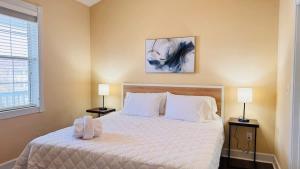 a bedroom with a large white bed with two lamps at Adorable 1BR condo with pool view at Magnolia in Myrtle Beach