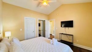 a bedroom with a white bed and a flat screen tv at Adorable 1BR condo with pool view at Magnolia in Myrtle Beach +22 photos