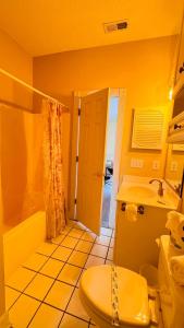 a yellow bathroom with a toilet and a sink at Adorable 1BR condo with pool view at Magnolia in Myrtle Beach