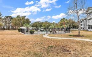 a park with a fence and a building at Adorable 1BR condo with pool view at Magnolia in Myrtle Beach