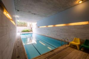 een zwembad met een gele stoel ernaast bij Award-winning White-spot in Athene