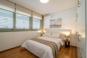 een witte slaapkamer met een bed en een raam bij Award-winning White-spot in Athene +24 foto's