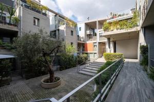 een binnenplaats van een appartementengebouw met een boom bij Award-winning White-spot in Athene