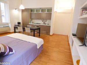 a bedroom with a bed and a table and a kitchen at Innoi in Cagliari
