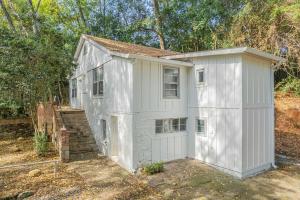 a white house with a garage in a yard at Classic City Apartment w Firepit in Athens