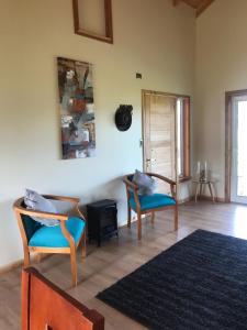 a living room with two chairs and a rug at Linda Casa en parcela, 3 minutos de frutillar Bajo in Frutillar