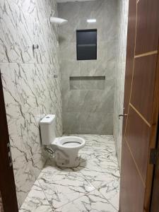 ein Bad mit WC und ein TV an der Wand in der Unterkunft Casa nova para alugar em Campina Grande toda mobiliada in Campina Grande