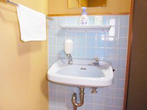 a white sink in a blue tiled bathroom at 河辺ふるさとの宿 in Ōzu