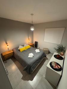 una camera da letto con un letto grande con cuscini gialli di Casa Serena Rio a Viedma