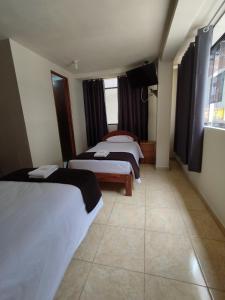 a hotel room with two beds and a window at Kuntur House Machupicchu in Machu Picchu +15 photos