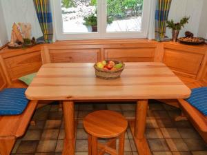 a wooden table with a bowl of fruit on it at Holiday home Waldhaus am Burbach in Bad Berleburg +8 photos