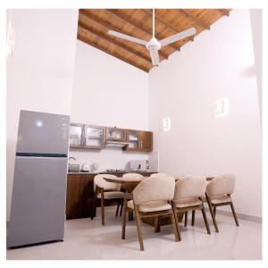 a kitchen with a table and chairs and a refrigerator at Diyawanna Villa - Deluxe Twin Room in Colombo in Sri Jayewardenepura Kotte