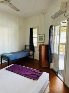 una stanza con due letti e una porta su una veranda di Exchange Hotel Backpacker Resort a Mossman Altre 63 foto