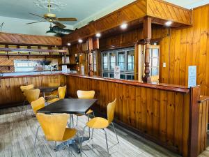 a restaurant with wooden walls and tables and chairs at Exchange Hotel Backpacker Resort in Mossman