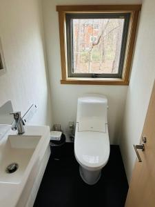 a bathroom with a toilet and a sink and a window at Hakuba Cottage ICHIZAEMON by Jade Group in Hakuba +15 photos