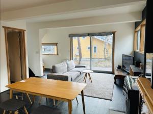 a living room with a couch and a table at Hakuba Cottage ICHIZAEMON by Jade Group in Hakuba